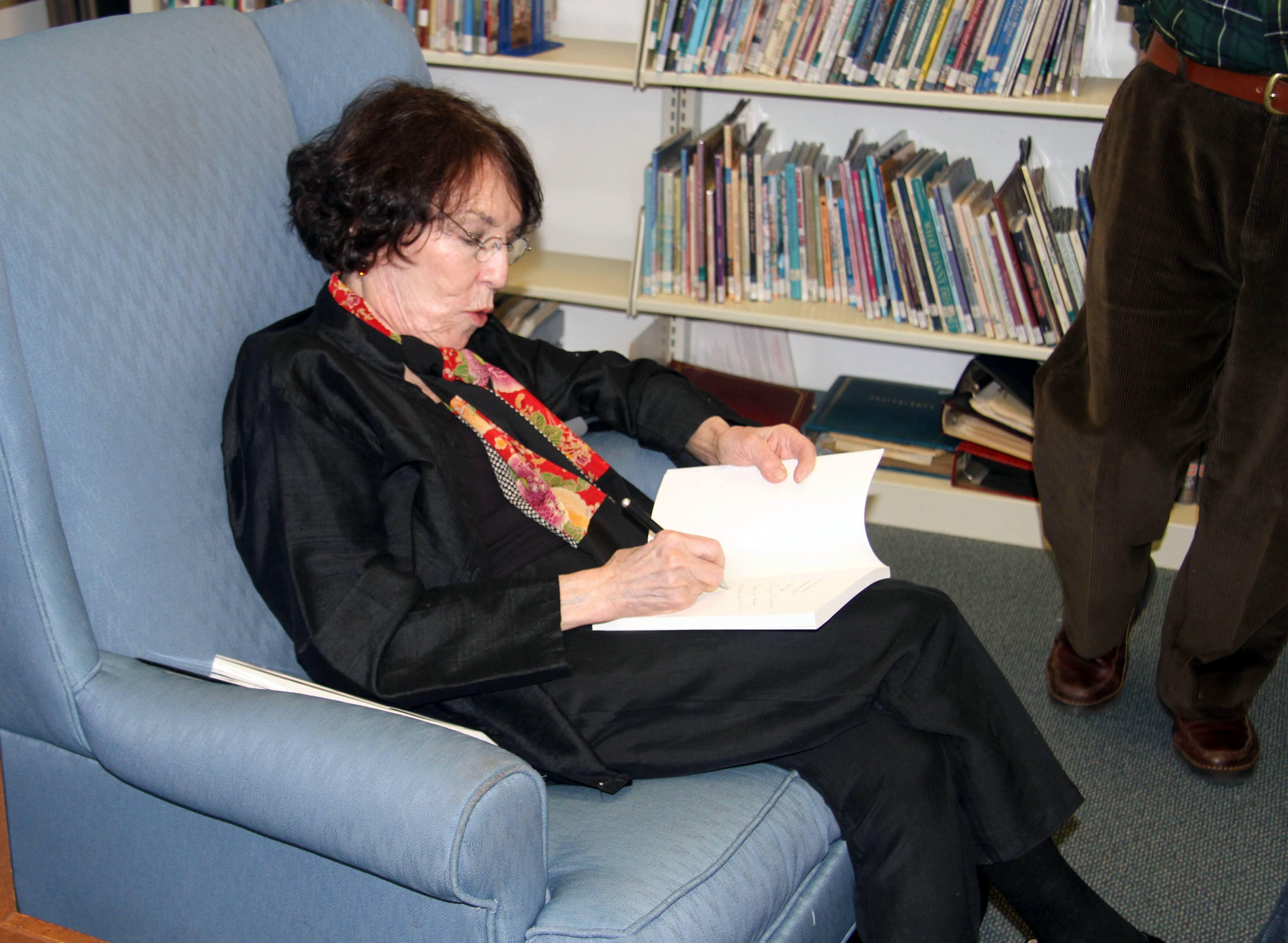 As she reads, autographs her …