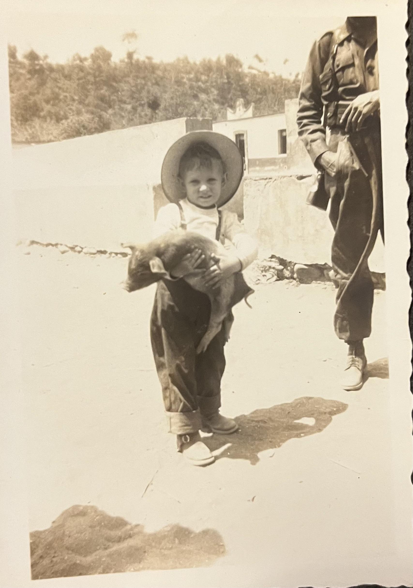 Linda holding a pig standing …